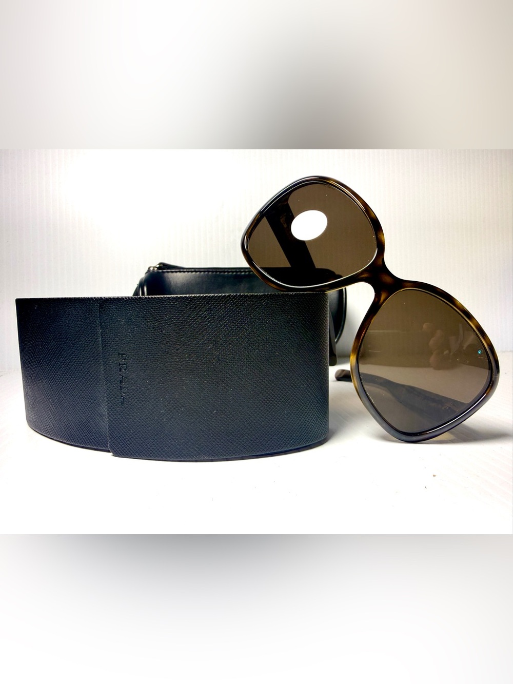 Prada Sunglasses with Tortoiseshell Frames and Two Cases .